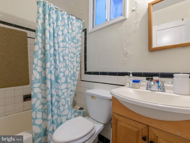 full bathroom featuring toilet, tile walls, vanity, and shower / bath combo with shower curtain