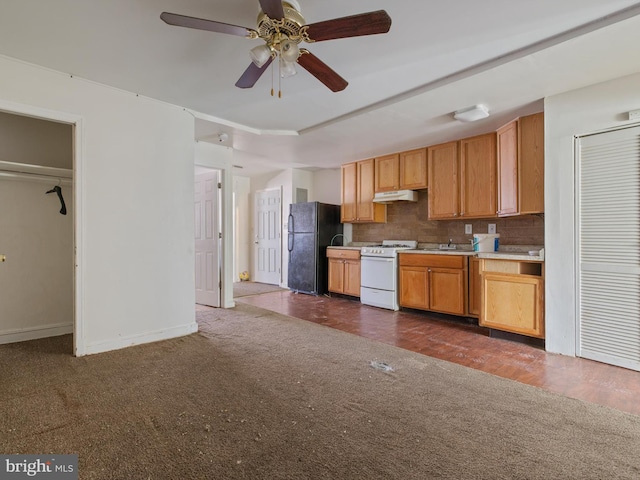 kitchen with dark colored carpet, a tray ceiling, black fridge, white range with gas cooktop, and decorative backsplash