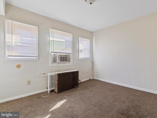 carpeted spare room featuring radiator and cooling unit