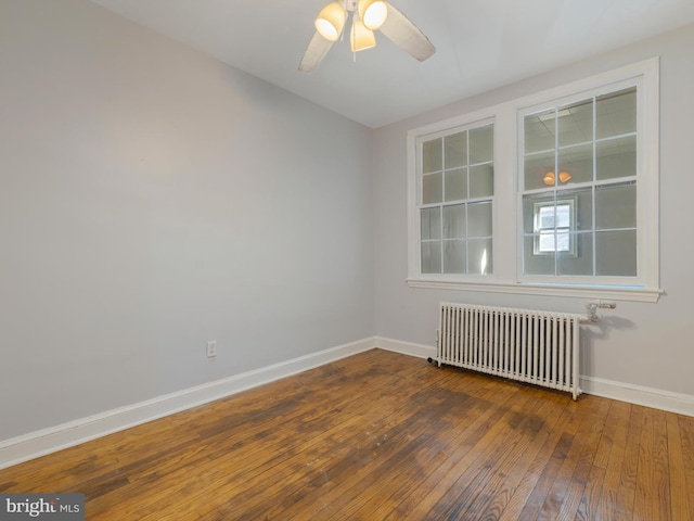 spare room with hardwood / wood-style floors, radiator heating unit, and ceiling fan