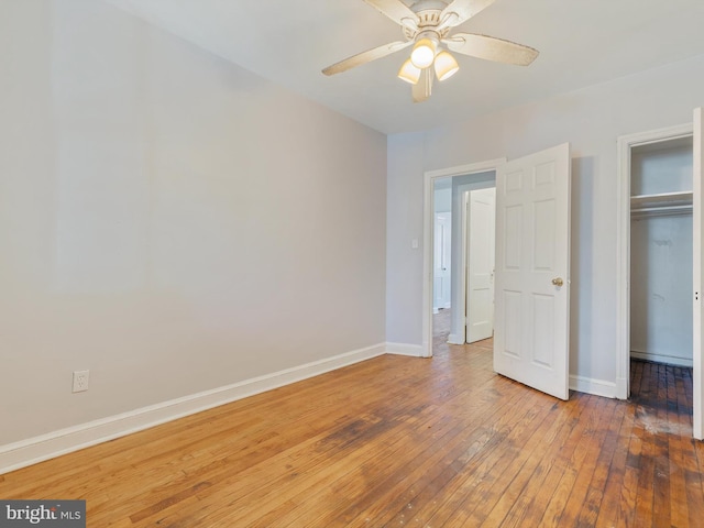 unfurnished bedroom featuring ceiling fan, hardwood / wood-style floors, and a closet