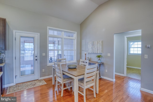 dining room featuring lofted ceiling and light hardwood / wood-style flooring