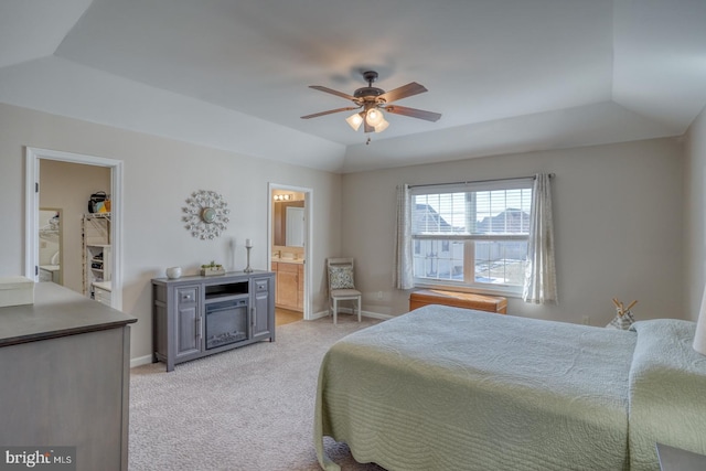 bedroom featuring a walk in closet, a tray ceiling, vaulted ceiling, and light colored carpet