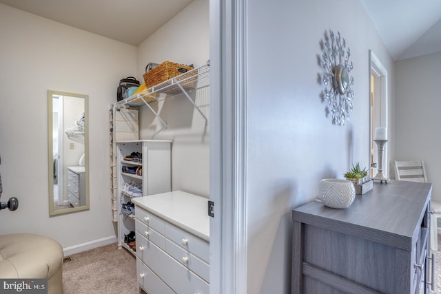 walk in closet featuring light colored carpet