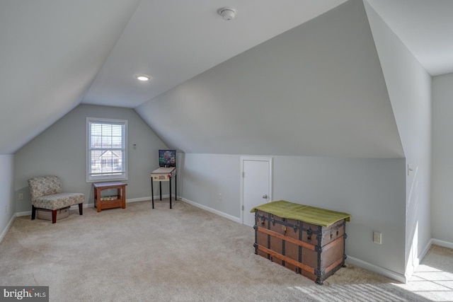 additional living space featuring vaulted ceiling and light colored carpet