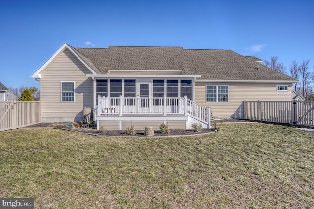 rear view of property with a sunroom and a yard