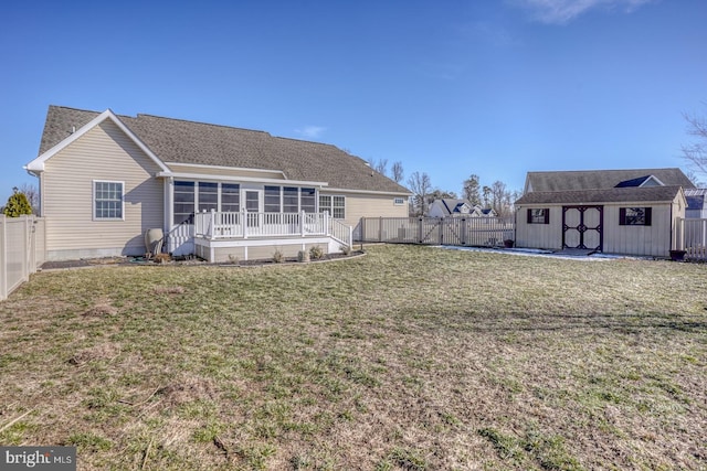 rear view of house with a storage shed, a sunroom, and a lawn