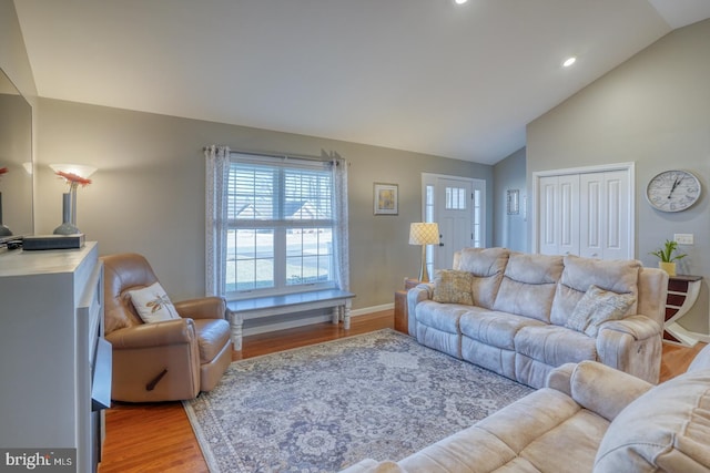 living room with light hardwood / wood-style flooring and high vaulted ceiling