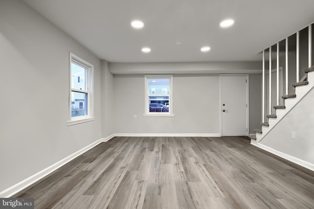 interior space featuring stairway, plenty of natural light, wood finished floors, and baseboards