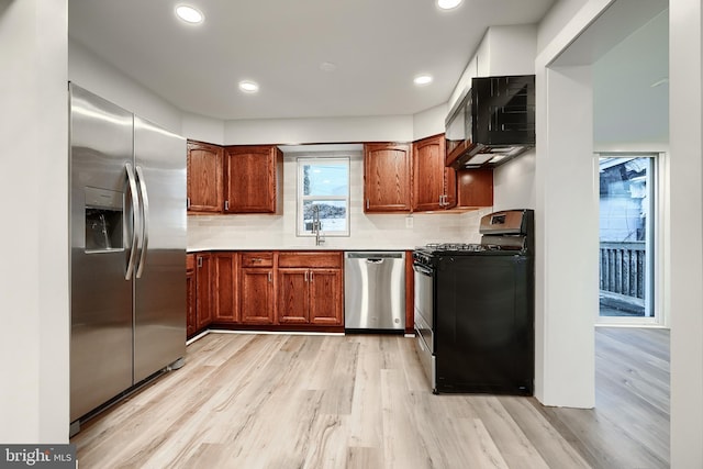 kitchen with recessed lighting, appliances with stainless steel finishes, light wood-type flooring, decorative backsplash, and brown cabinets