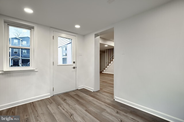 foyer with recessed lighting, stairway, baseboards, and wood finished floors