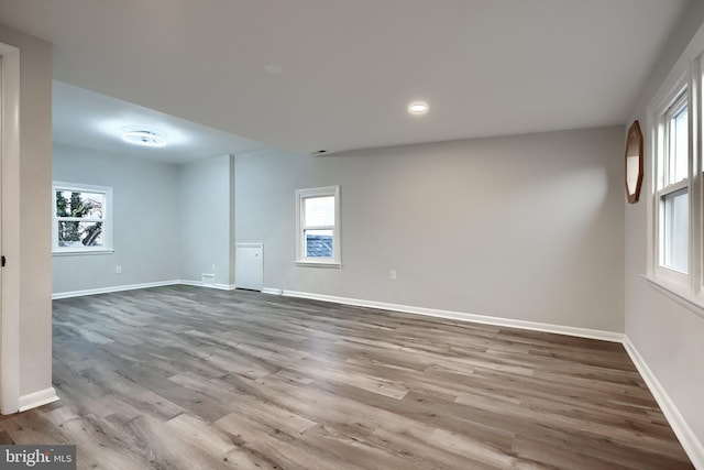 unfurnished room with recessed lighting, wood finished floors, and baseboards