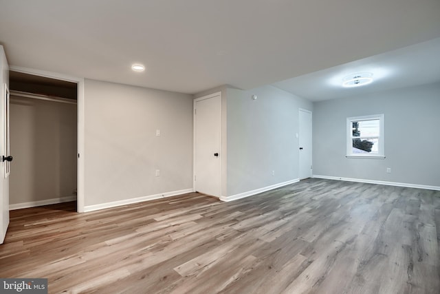 basement with baseboards and wood finished floors