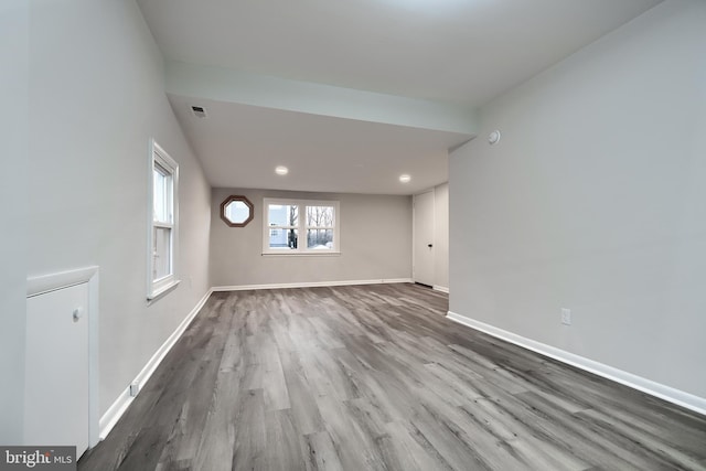 spare room with wood finished floors, visible vents, and baseboards