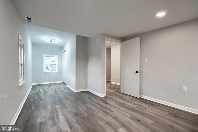 empty room featuring visible vents, baseboards, and wood finished floors