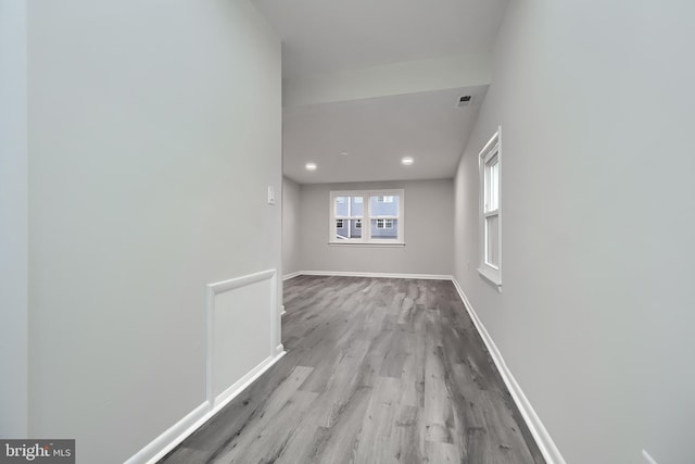 hall with visible vents, baseboards, wood finished floors, and recessed lighting