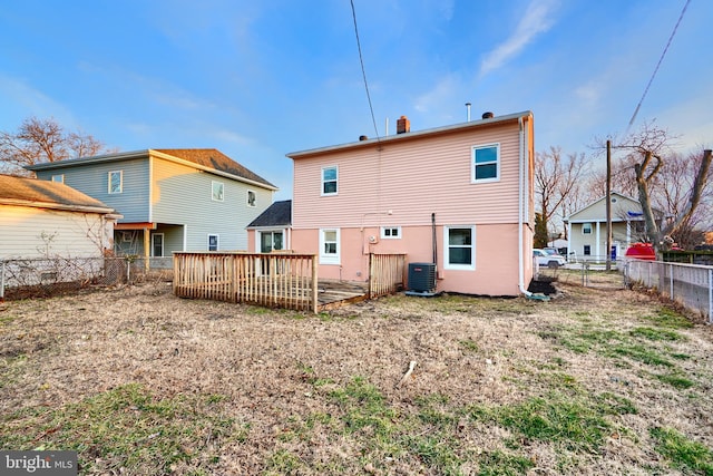 back of property featuring fence, a chimney, a wooden deck, and central air condition unit