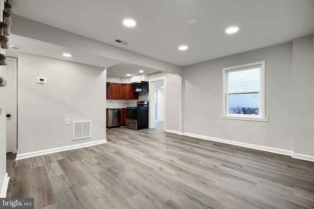 unfurnished living room with baseboards, visible vents, and light wood finished floors