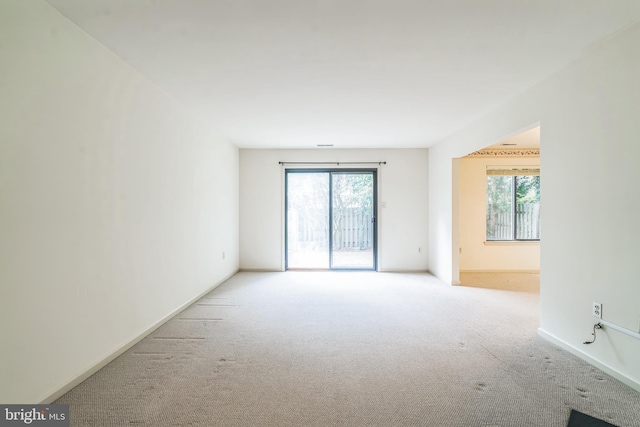 carpeted empty room with plenty of natural light