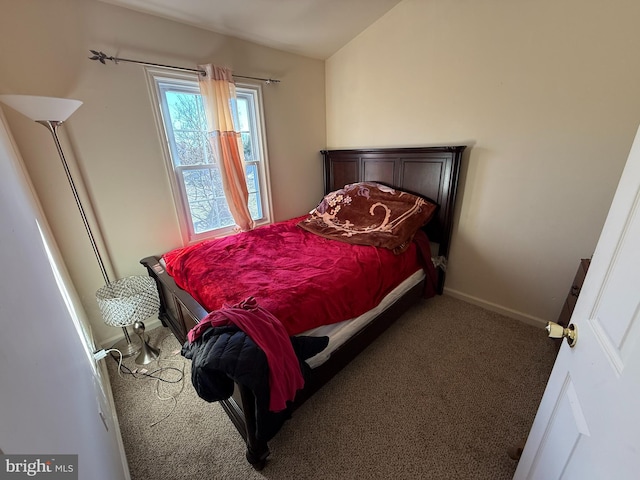 bedroom featuring dark carpet and vaulted ceiling