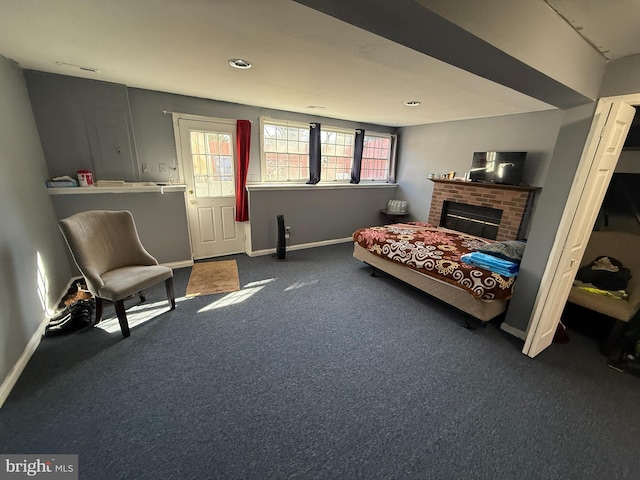 carpeted bedroom with a brick fireplace