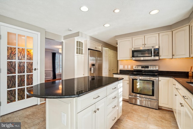 kitchen featuring light tile patterned floors, a center island, and appliances with stainless steel finishes