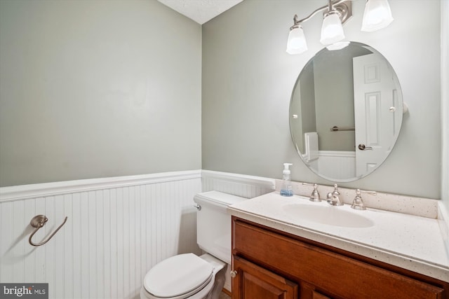 bathroom featuring vanity, a chandelier, and toilet