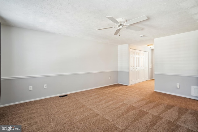 unfurnished room with ceiling fan, a textured ceiling, and carpet flooring