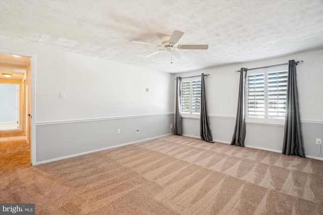 carpeted spare room with ceiling fan and a textured ceiling