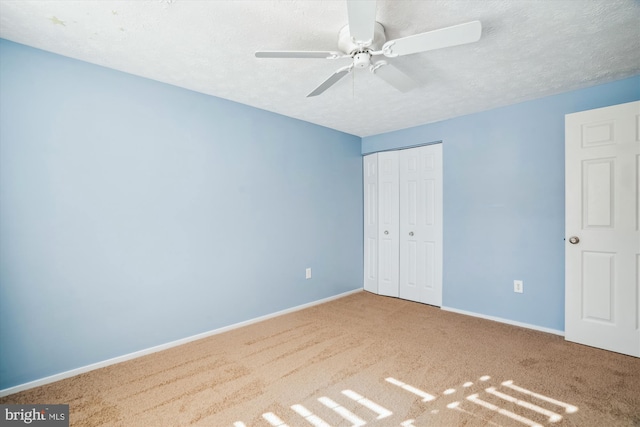 unfurnished bedroom with ceiling fan, a closet, carpet flooring, and a textured ceiling