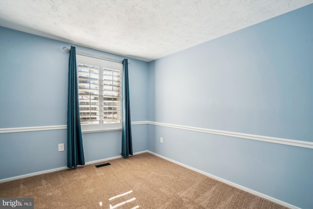 carpeted spare room with a textured ceiling