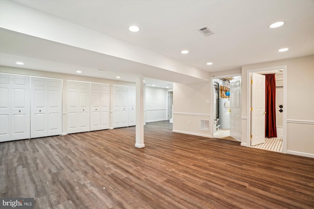 basement with hardwood / wood-style flooring and electric water heater