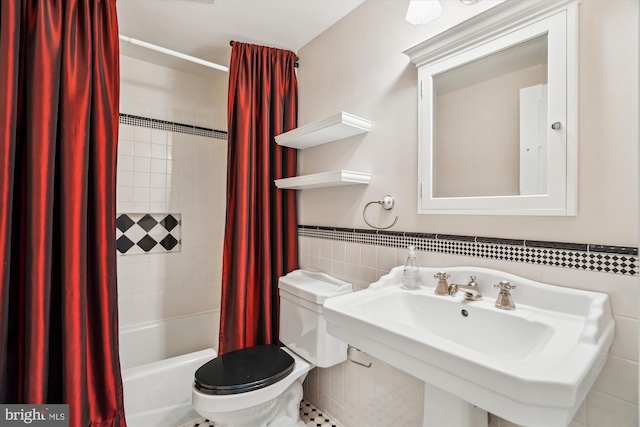 full bathroom featuring toilet, sink, tile walls, and shower / bath combo with shower curtain