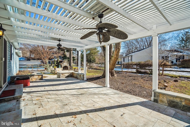 view of patio / terrace featuring ceiling fan, a pergola, and an outdoor stone fireplace