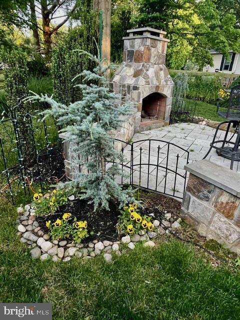 view of yard featuring a patio and an outdoor stone fireplace