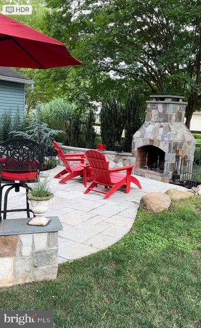 view of patio / terrace featuring an outdoor stone fireplace