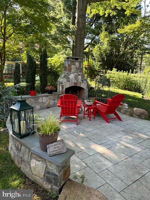 view of patio featuring an outdoor stone fireplace