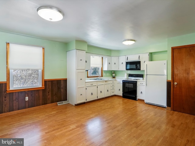 kitchen featuring white refrigerator, white cabinets, sink, and range with electric stovetop