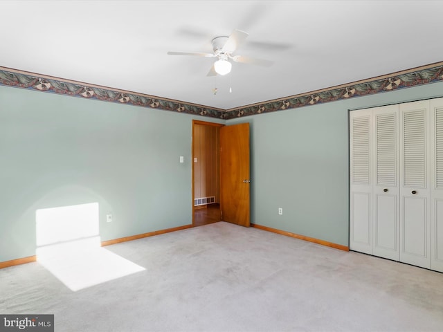 unfurnished bedroom featuring light carpet, a closet, and ceiling fan