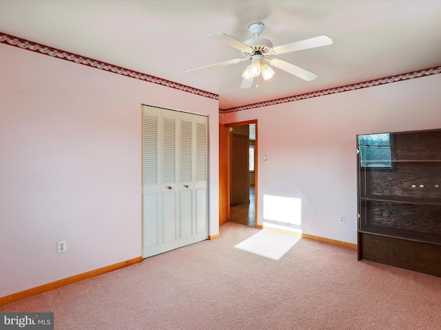 unfurnished bedroom featuring ceiling fan, a closet, and light carpet