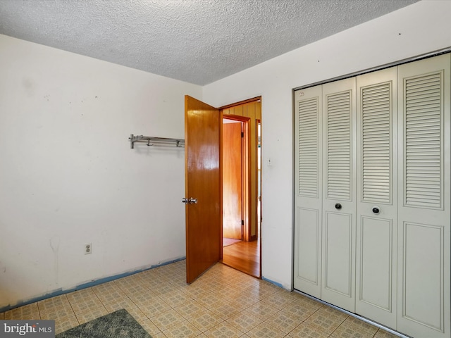 unfurnished bedroom with a closet and a textured ceiling