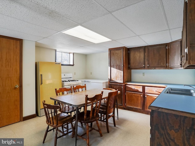 dining space featuring sink and a drop ceiling