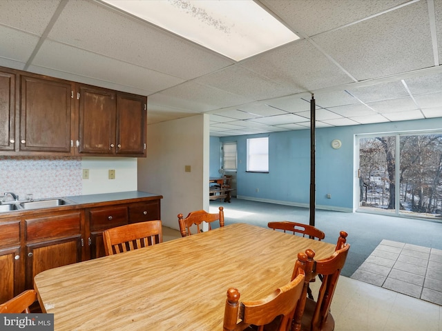 dining area with sink and a paneled ceiling