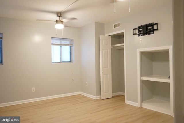 unfurnished bedroom with a closet, visible vents, a ceiling fan, light wood-type flooring, and baseboards