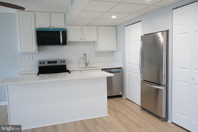 kitchen featuring light countertops, appliances with stainless steel finishes, white cabinetry, a sink, and light wood-type flooring