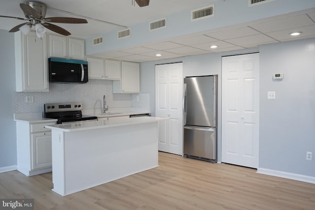 kitchen featuring light countertops, appliances with stainless steel finishes, a sink, and visible vents