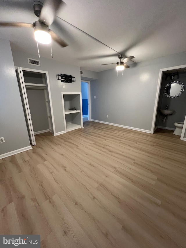 unfurnished bedroom featuring light wood-style floors, baseboards, visible vents, and ceiling fan