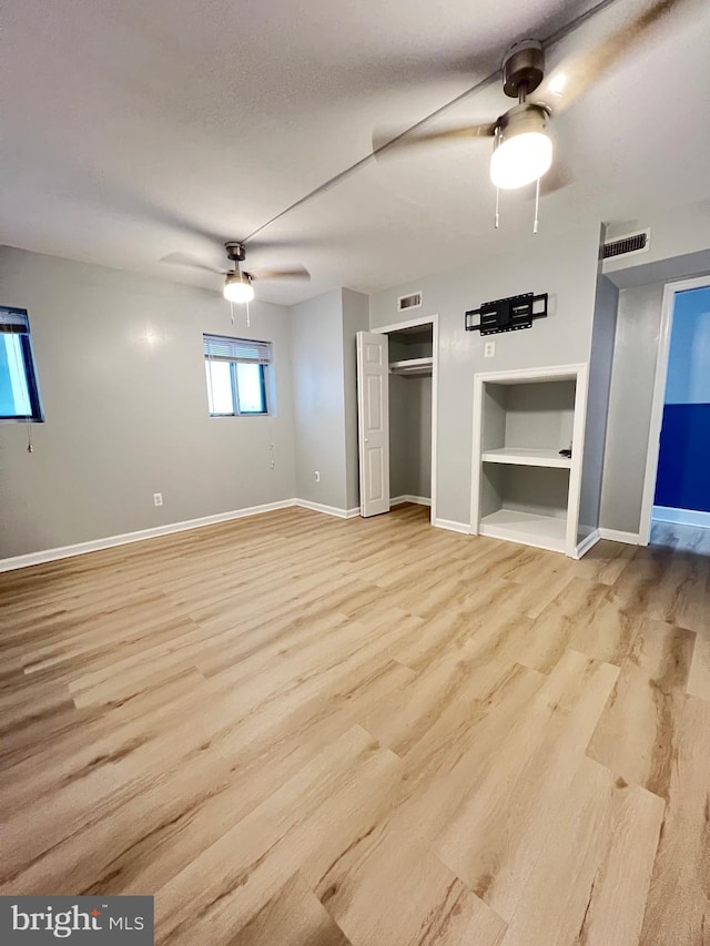 unfurnished bedroom featuring light wood finished floors, a ceiling fan, visible vents, and baseboards