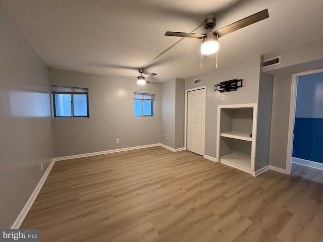 unfurnished bedroom with ceiling fan, wood finished floors, visible vents, and baseboards