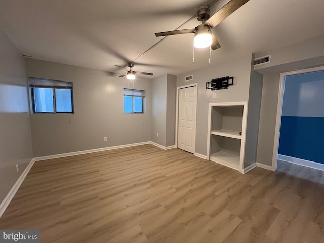 unfurnished bedroom with baseboards, visible vents, and wood finished floors